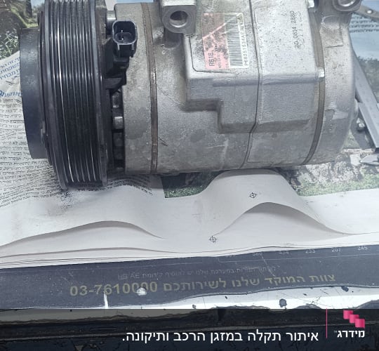 מדחס רכב על שולחן עבודה עם כלים מסביב